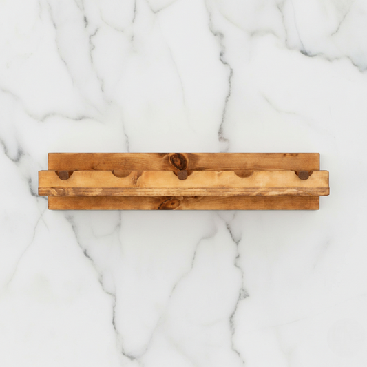 Handmade solid wood wall-mounted wine rack in dark walnut with floating shelf design, modern rustic furniture style.