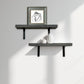 Two dark gray wall shelves with a framed picture and small decorative items on a light gray wall.
