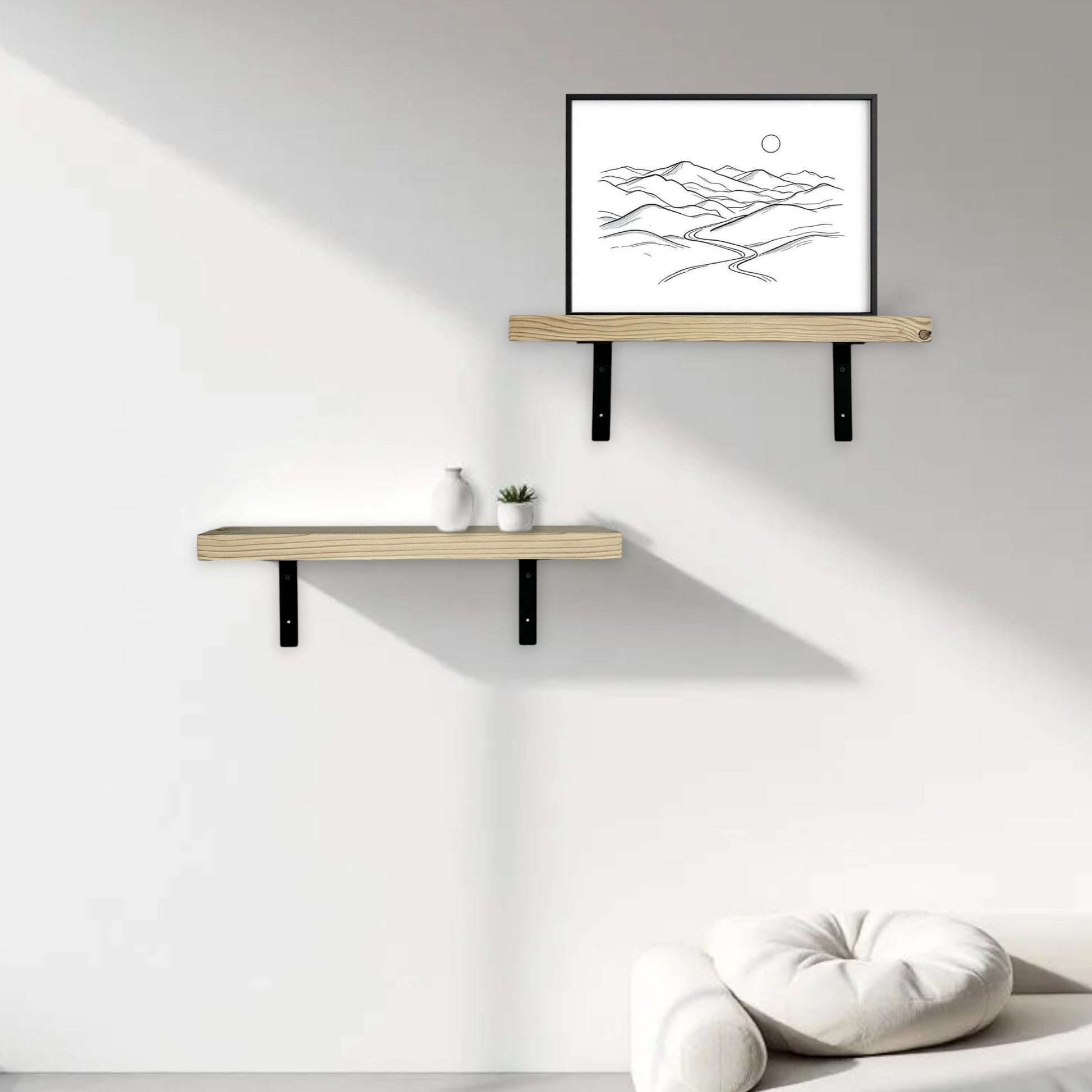 Two wooden shelves on a white wall with a framed black and white abstract art piece.
